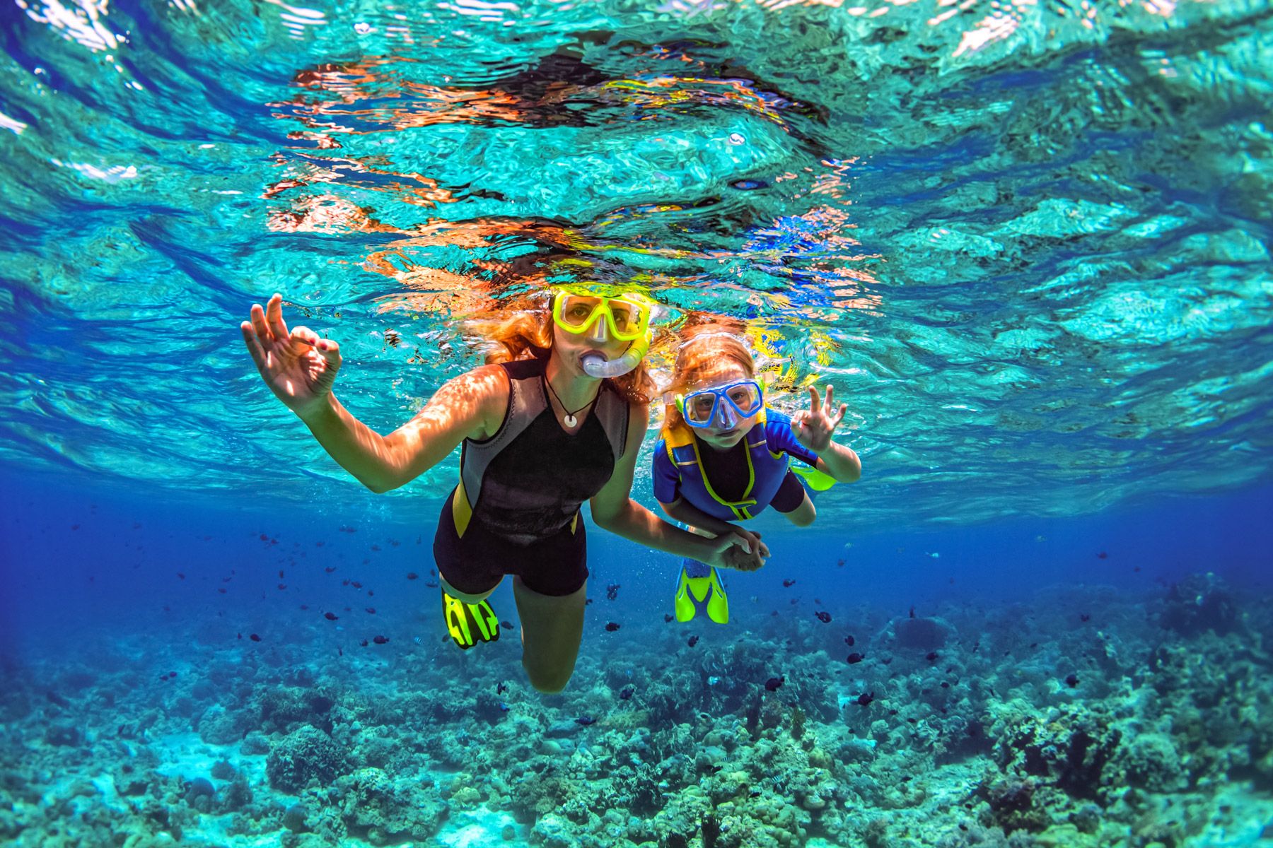 mother kid snorkeling coral reef