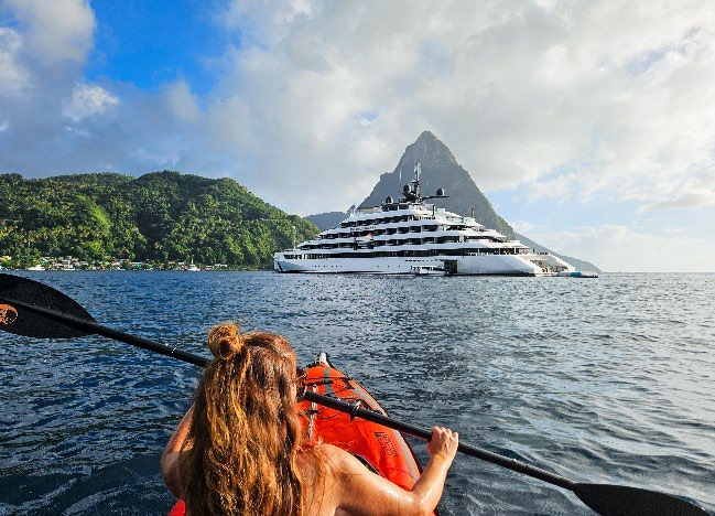 Luxury yacht anchored in Mediterranean bay with kayaker